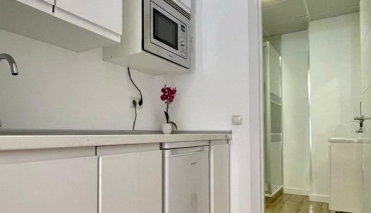 Minimalista cocina blanca en Hotel Madrid Río, alojamiento con servicios modernos y comodidad en Madrid.