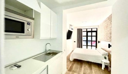 Amplia habitación de hotel en Madrid Río con cocina equipada y moderno diseño, ideal para estancias cómodas cerca del río y puntos turísticos de Madrid.