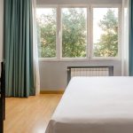 Habitación moderna y luminosa en Hotel Madrid Río con vistas al parque y conexión Wi-Fi gratuita.