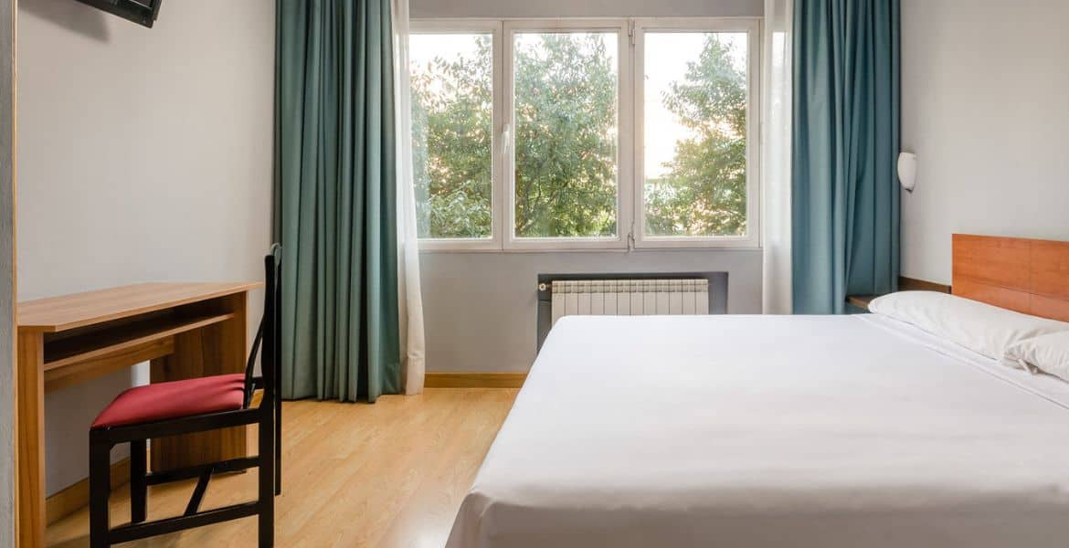 Habitación moderna y luminosa en Hotel Madrid Río con vistas al parque y conexión Wi-Fi gratuita.