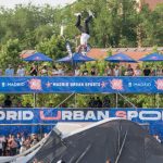Joven haciendo un salto acrobático en una competición de deportes urbanos en Madrid.