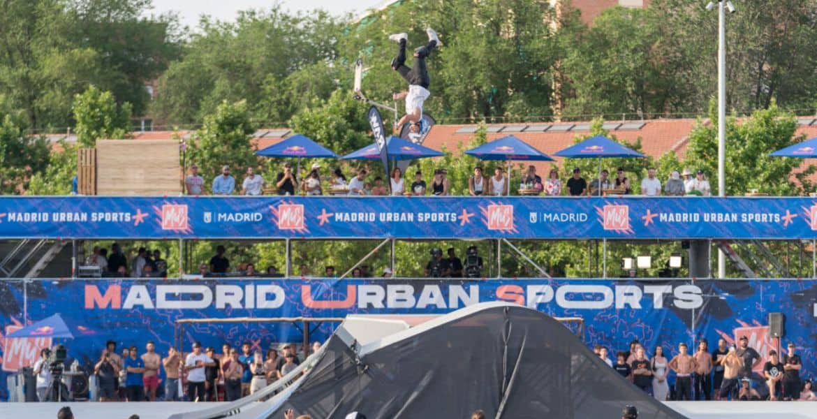 Joven haciendo un salto acrobático en una competición de deportes urbanos en Madrid.
