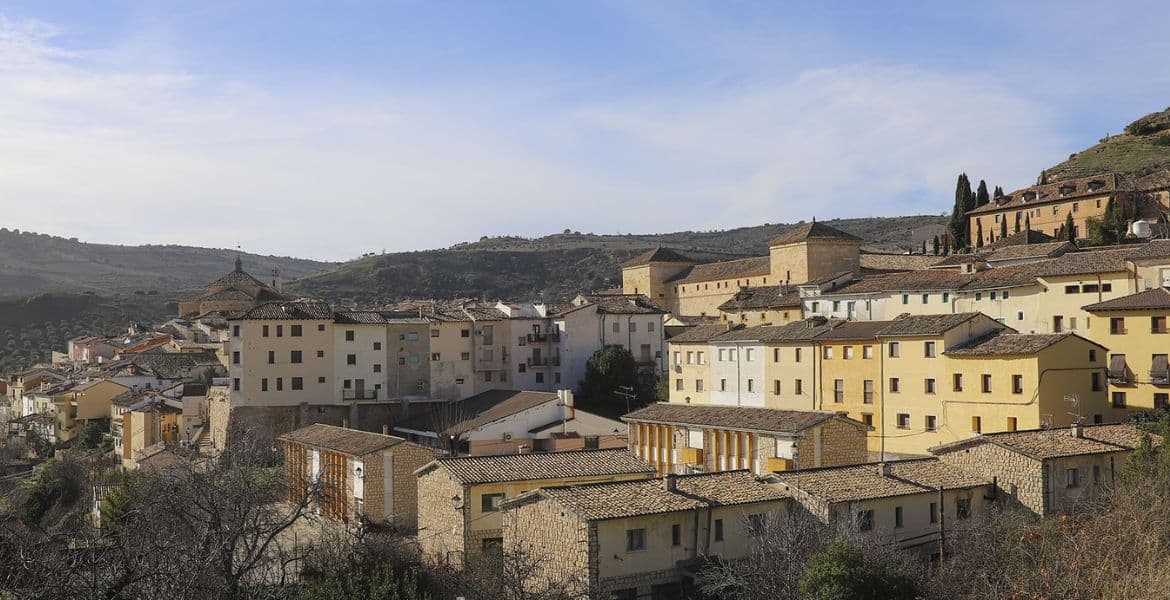 Paisaje urbano de la ciudad histórica de Madrid Río con casas tradicionales y colinas cercanas.