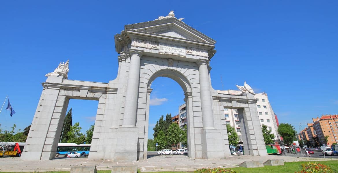 Arco de Alcalá en Madrid, monumento histórico cerca del Hotel Madrid Río, con arquitectura clásica y detalles escultóricos, en un día soleado en Madrid.