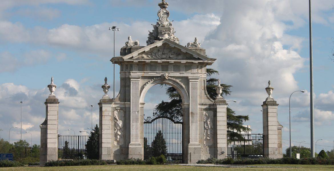 Puerta histórica en las instalaciones del Hotel Madrid Río, cerca del río Manzanares, en Madrid, destacando arquitectura clásica y zona de ocio.