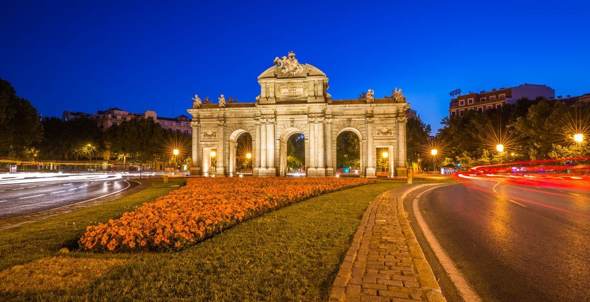 Arco de Cibeles iluminado por la noche en Madrid, símbolo emblemático y turístico, cerca del Ayuntamiento y centros históricos.