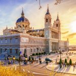 Majestuoso edificio religioso en Madrid con arquitectura barroca y neoclásica, ubicado cerca del río y con vistas panorámicas de la ciudad al atardecer.