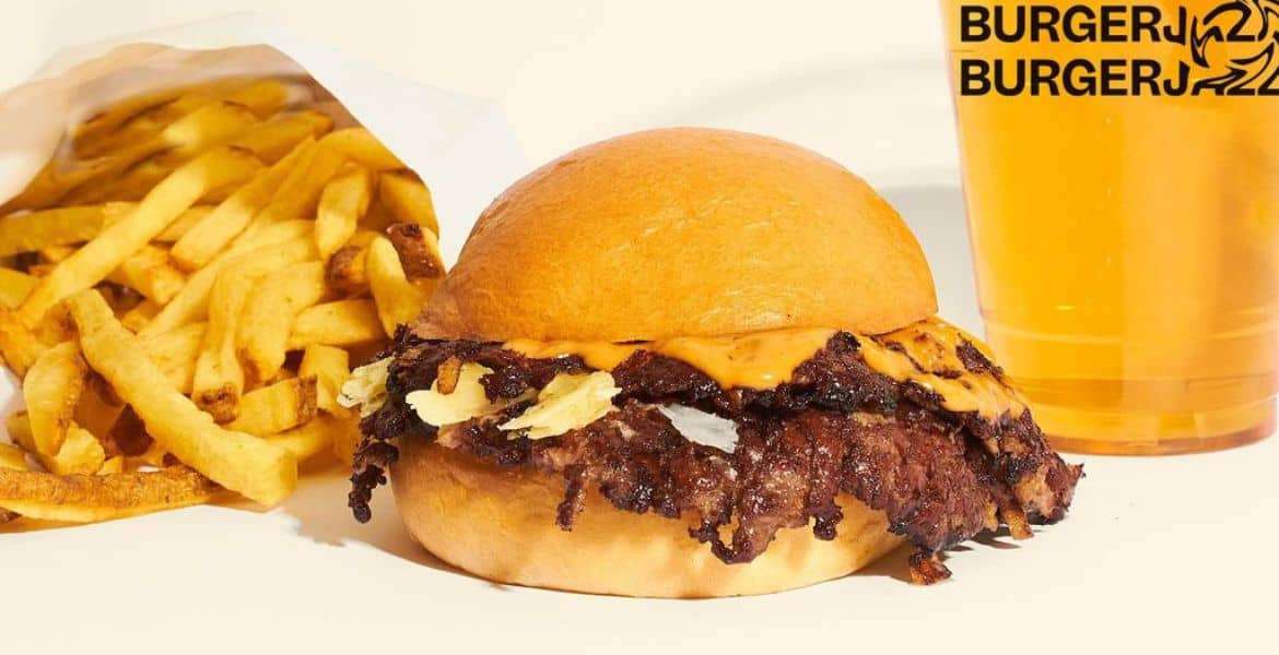 Una hamburguesa con papas fritas y cerveza en un restaurante de comida rápida.