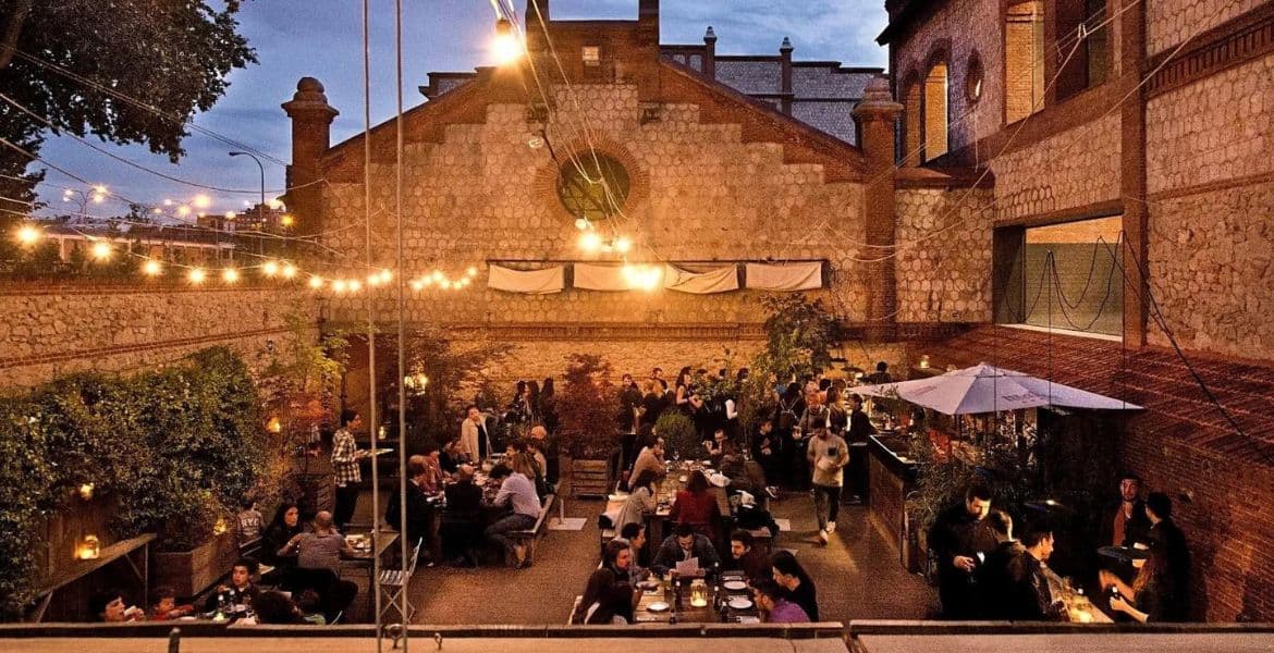 Jardín exterior del Hotel Madrid Río con ambiente nocturno y luces decorativas, ideal para cenas al aire libre y eventos en Madrid.