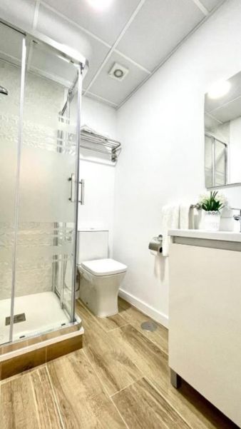 Lujosa habitación del Hotel Madrid Río con baño moderno y ducha de cristal, ideal para una estancia cómoda en Madrid.