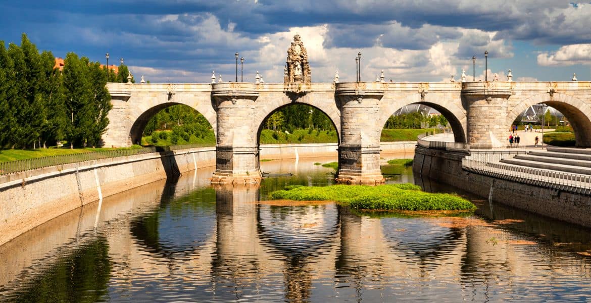 Puente de piedra en el río Manzanares en Madrid, atractiva vista del centro histórico, ideal para turismo, paseos y fotografía en la ciudad.