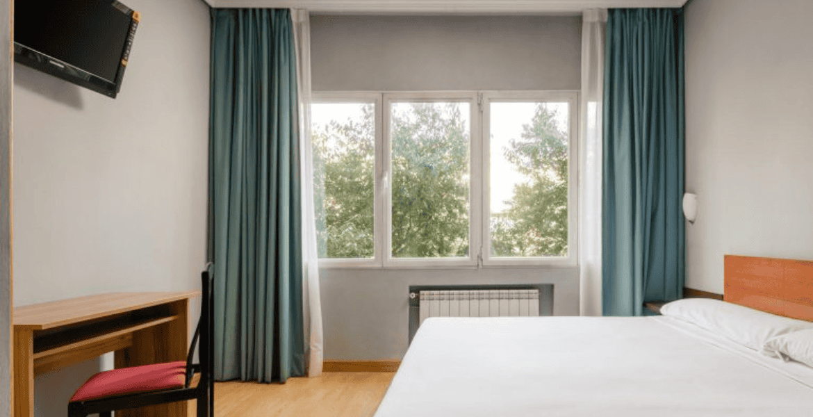 Habitación moderna en Hotel Madrid Río con vistas a la naturaleza y ambiente acogedor.