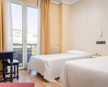 Habitación doble moderna en Hotel Madrid Río con vista a la ciudad y servicio de calidad.
