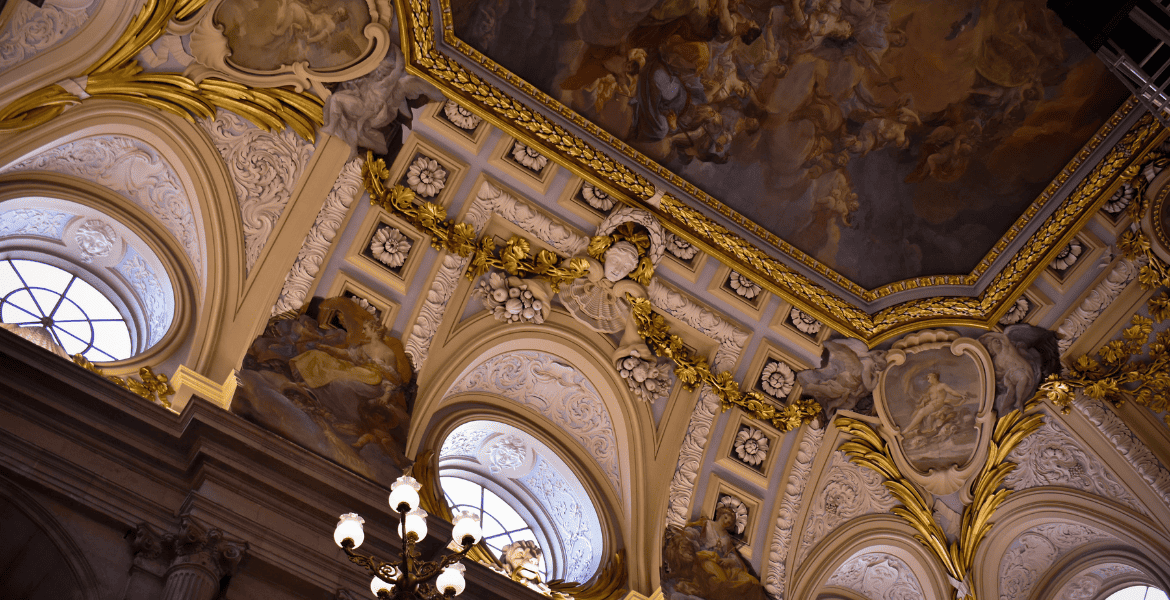 Majestuoso techo decorado con detalles barrocos, esculturas doradas y frescos en el interior del Hotel Madrid Río.