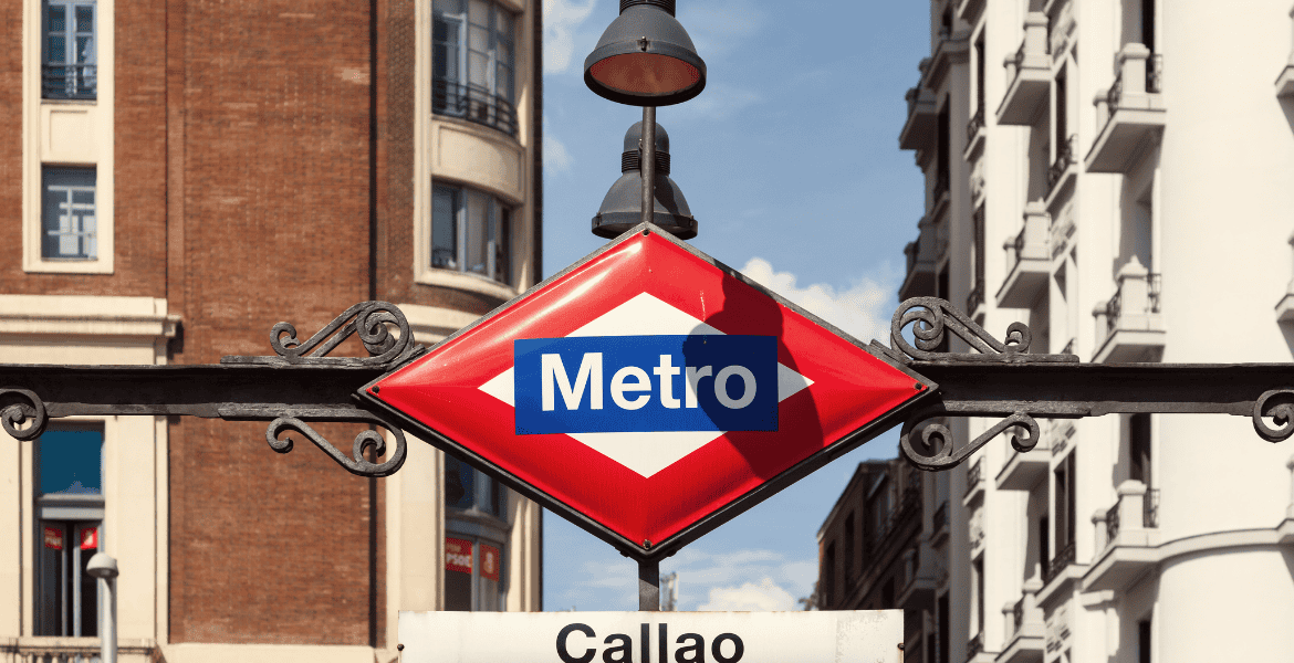 Entrada de metro en Madrid con señalización y arquitectura urbana moderna.
