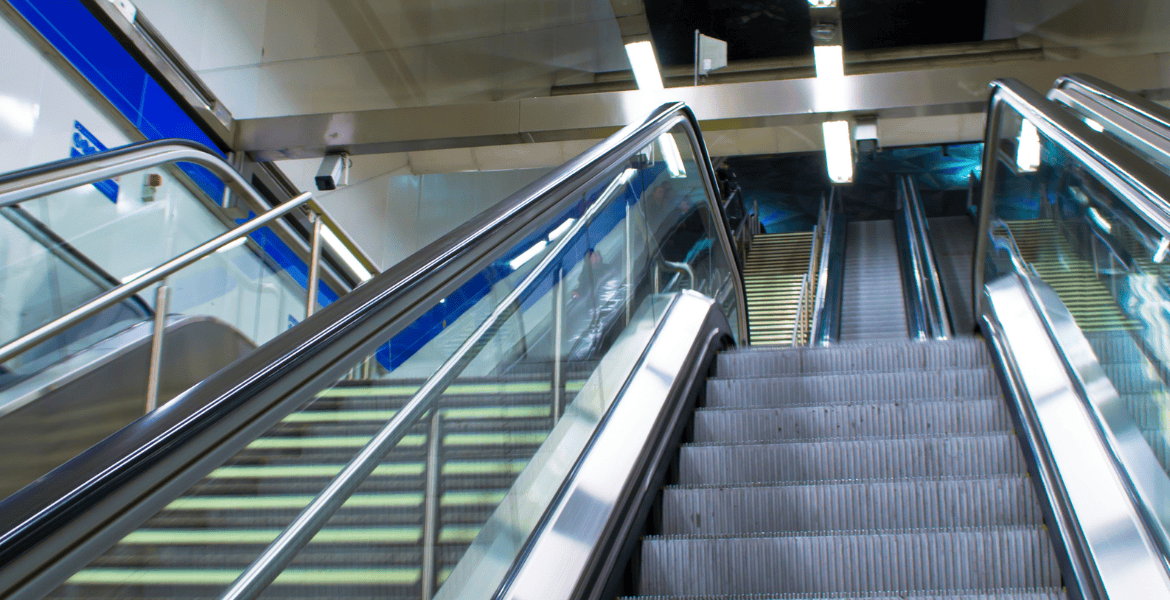 Escalera mecánica moderna en estación de metro de Madrid, acceso fácil y seguro para viajeros, cerca del Hotel Madrid Río, perfecto para desplazarse por la ciudad.