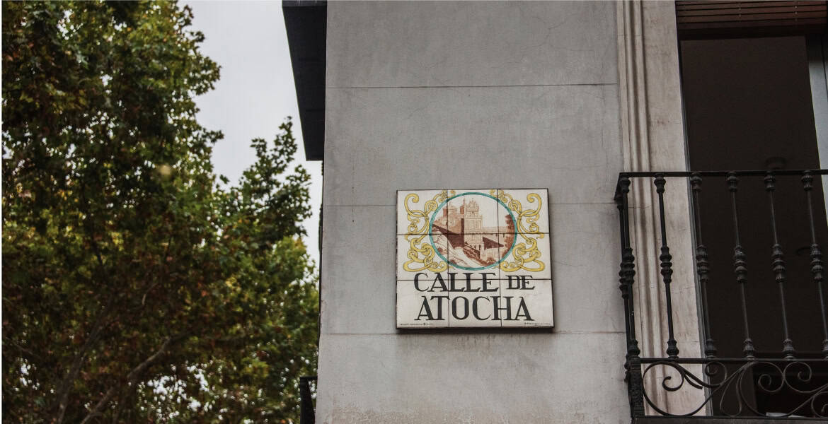 Calle de Atocha Madrid Río, señal de calle histórica en Madrid con vista al casco antiguo y zonas verdes cercanas.