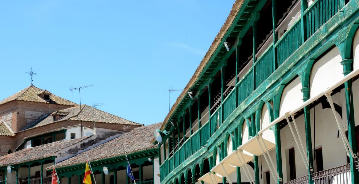 Amplia vista de la fachada del Hotel Madrid Río con arquitectura tradicional y balcones verdes, cercano a zonas turísticas de Madrid para una estancia cómoda.