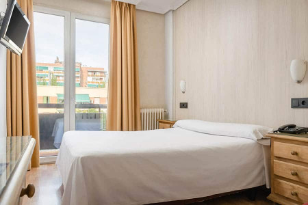 Cómoda habitación de hotel en Madrid Río con balcones y ambiente acogedor.