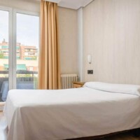 Cómoda habitación de hotel en Madrid Río con balcones y ambiente acogedor.