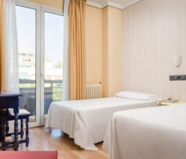 Habitación moderna y cómoda en Hotel Madrid Río con vistas a la ciudad, perfecta para turistas y viajeros en Madrid.