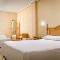 Habitación doble con mobiliario en madera y estilo clásico, ideal para una estancia confortable en el Hotel Madrid Río.