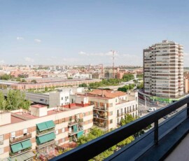 Vistas panorámicas de Madrid desde un balcón, impresionantes edificios y skyline urbano con cielo despejado, ideal para alojamiento en Hotel Madrid Río.
