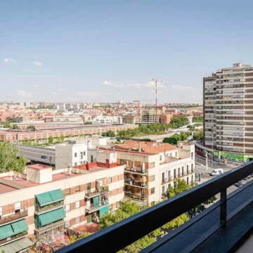 Vistas panorámicas de Madrid desde un balcón, impresionantes edificios y skyline urbano con cielo despejado, ideal para alojamiento en Hotel Madrid Río.