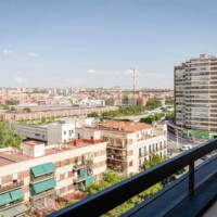 Vistas panorámicas de Madrid desde un balcón, impresionantes edificios y skyline urbano con cielo despejado, ideal para alojamiento en Hotel Madrid Río.