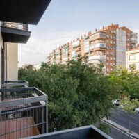 Vistas desde el balcón del Hotel Madrid Río con árboles y edificios urbanos en un entorno tranquilo y moderno.