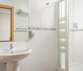 Limpieza y funcionalidad en habitaciones del Hotel Madrid Río, con baño moderno y espacio cómodo para una estancia cómoda en Madrid.