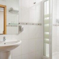 Limpieza y funcionalidad en habitaciones del Hotel Madrid Río, con baño moderno y espacio cómodo para una estancia cómoda en Madrid.