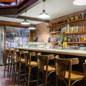 Techo de madera y ladrillos vista en bar de hotel en Madrid Río.