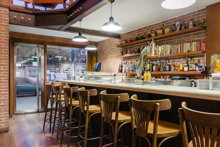 Techo de madera y ladrillos vista en bar de hotel en Madrid Río.