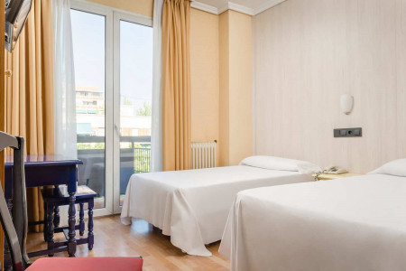 Habitaciones modernas en Hotel Madrid Río con vistas al balcón y comodidades cómodas para una estancia agradable.