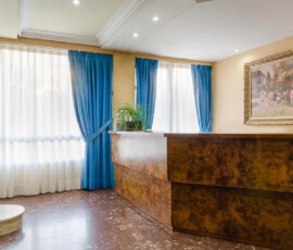 Puerta de entrada del hotel con vistas a la recepción y decoración clásica, cerca del río y zonas turísticas de Madrid.