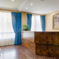 Puerta de entrada del hotel con vistas a la recepción y decoración clásica, cerca del río y zonas turísticas de Madrid.