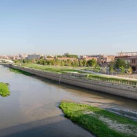Vistas del río Manzanares y el Parque del Madrid Río con zonas verdes y arquitectura moderna en Madrid.