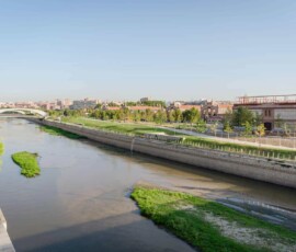 Vistas del río Manzanares y el Parque del Madrid Río con zonas verdes y arquitectura moderna en Madrid.