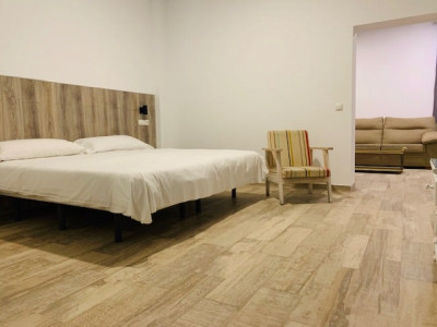 Amplia habitación de hotel en Madrid con cama doble, moderna decoración y zona de descanso con sofá, ubicada en Hotel Madrid Río, confort y alojamiento céntrico en Madrid.