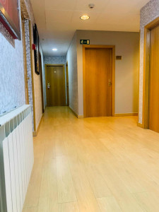 Puerta de habitación en hotel Madrid Río con suelo de madera y paredes decoradas, área interior moderna y acogedora, cerca del río y parques de Madrid.