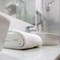 Lavabo con toallas blancas en baño moderno en Hotel Madrid Río, alojamiento céntrico en Madrid con instalaciones cómodas y elegantes.