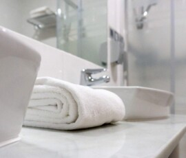 Lavabo con toallas blancas en baño moderno en Hotel Madrid Río, alojamiento céntrico en Madrid con instalaciones cómodas y elegantes.