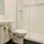 Acceso a habitaciones con baño privado en Hotel Madrid Río, con ducha moderna y amenities de calidad. Ubicación céntrica en Madrid, ideal para turistas y viajantes.