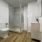 Moderno baño en Hotel Madrid Río con ducha de cristal y WC suspendido.