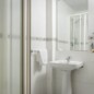 Puerta de baño en hotel Madrid Río con ducha y lavabo.