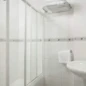 Línea de descripción alternativa en SEO: Ducha moderna y lavabo en baño limpio del Hotel Madrid Río, alojamiento en Madrid cerca del río y principales atracciones de la ciudad.