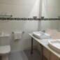 Baño moderno en Hotel Madrid Río con lavabo doble y espejo amplio, ideal para huéspedes que buscan comodidad y funcionalidad cerca del centro de Madrid.