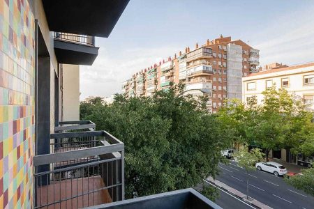 Vistas desde un balcón en el Hotel Madrid Río, con edificios residenciales y árboles en una típica calle de Madrid, perfecta para alojarse cerca del río y de zonas de ocio y cultura.