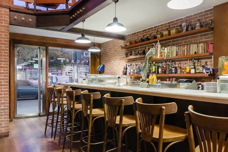 - Moderno bar en hotel Madrid Río con ambiente acogedor y mobiliario de madera.